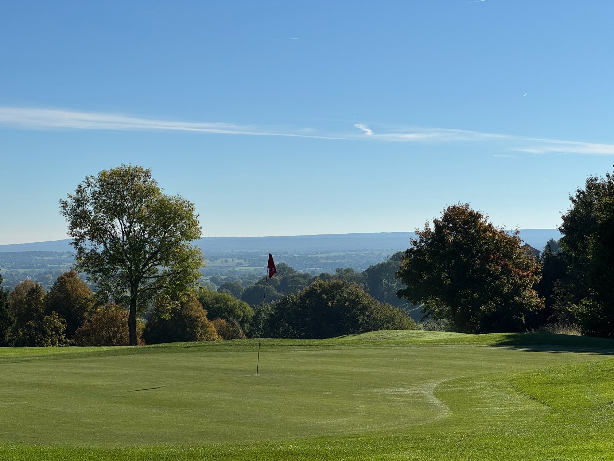 Golf Henri Chapelle - green avec drapeau et vue sur les Ardennes