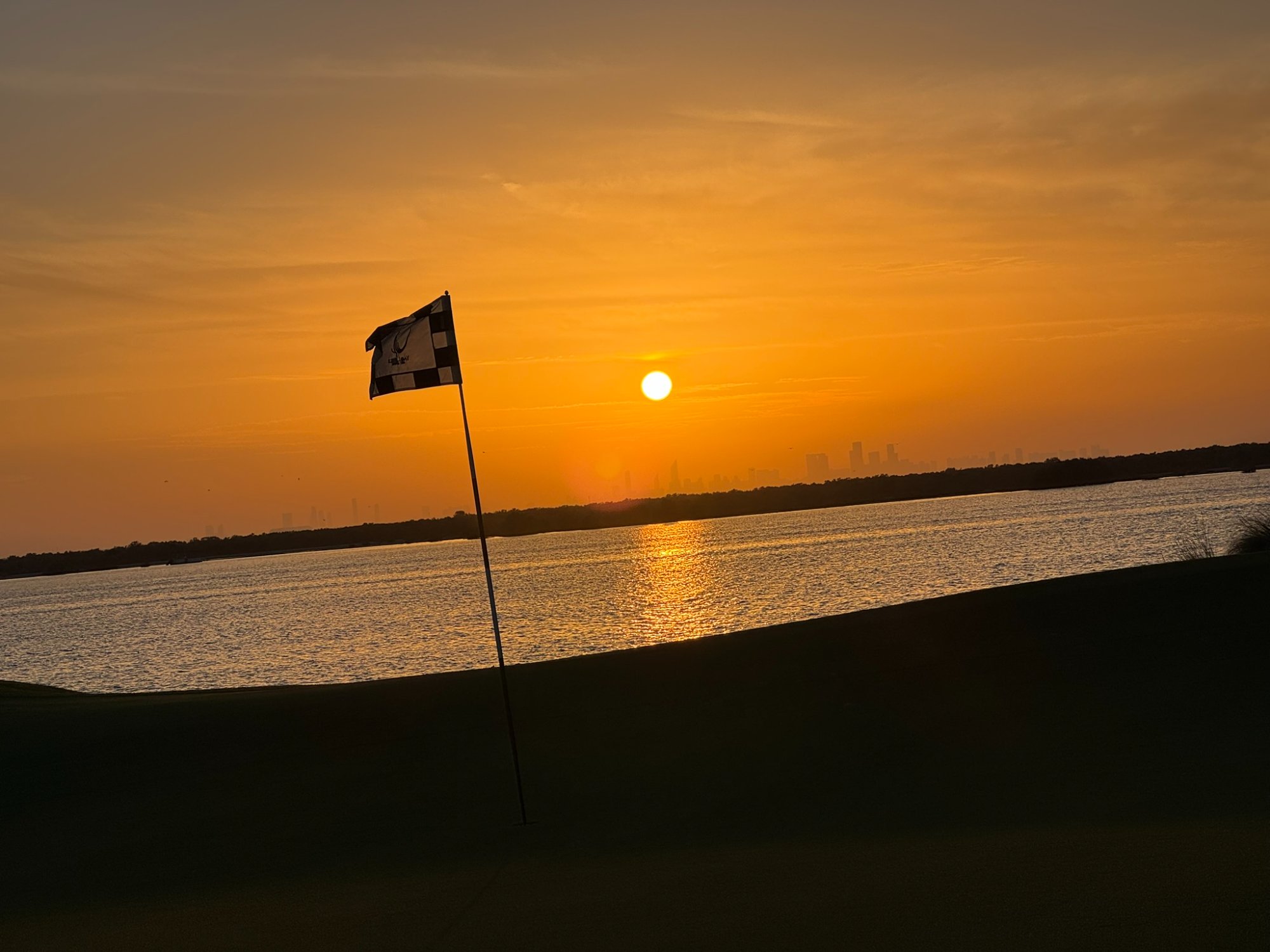 Yas Links - drapeau au coucher de soleil sur le Golfe